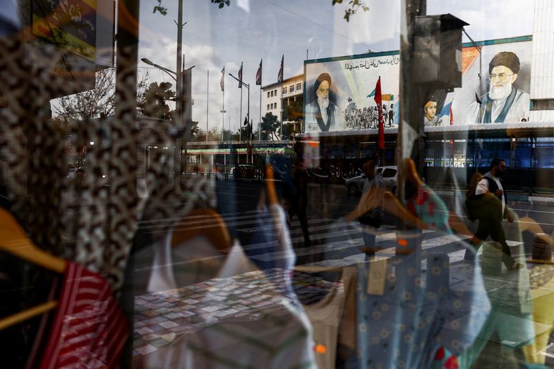 A mural depicting the late leader of the Islamic Revolution, Ayatollah Ruhollah Khomeini, and the late Iran's Supreme Leader Ayatollah Ali Khamenei, is reflected on a window display of a shop, amid the U.S.-Israeli conflict with Iran, in Tehran, Iran, March 22, 2026. Majid Asgaripour/WANA (West Asia News Agency) via REUTERS