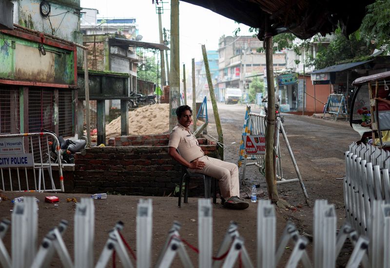 A police officer sits as he guards a street following the rape and murder of an 11-year-old girl in a town near Kolkata, West Bengal, India, July 11, 2026. REUTERS/Sahiba Chawdhary