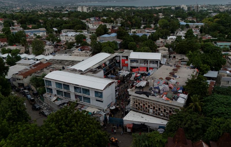 FILE PHOTO: A drone view shows makeshift tents and people camping on the roof at the Lycee Marie-Jeanne, a school turned into a shelter for some of the more than 1.3 million Haitians who have been internally displaced due to gang violence, in Port-au-Prince, Haiti, October 28, 2025. REUTERS/Herbert Villarraga/File Photo
