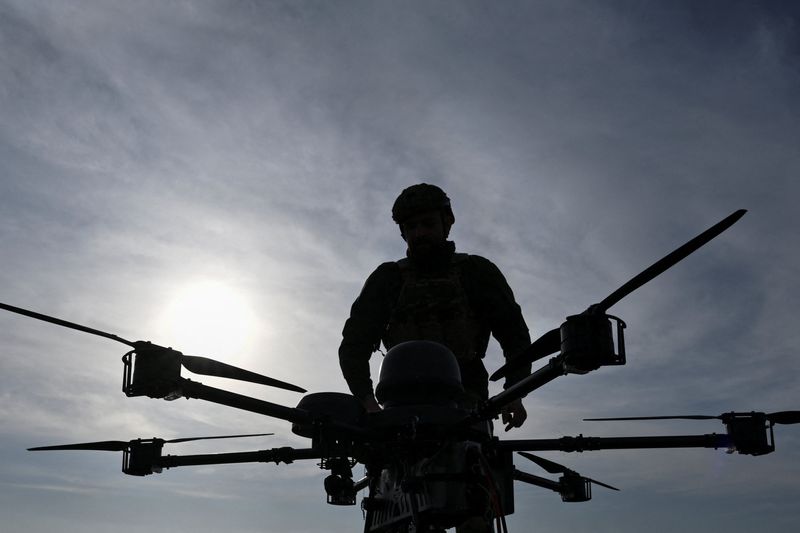 A service member of the 422nd Unmanned Systems Regiment stands next to a heavy strike drone at a training ground, amid Russia's attack on Ukraine, in Zaporizhzhia region, Ukraine March 23, 2026. REUTERS/Stringer