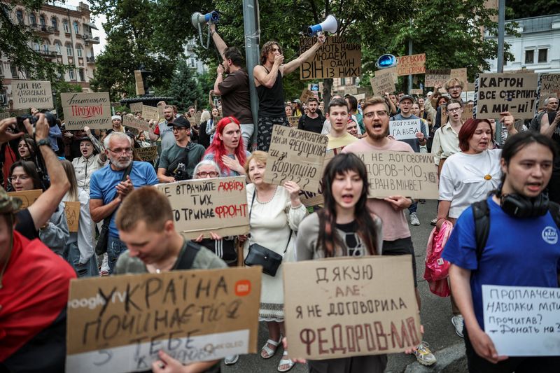 Participants hold signs and shout slogans during a rally to protest against Ukrainian President Volodymyr Zelenskiy's decision to replace Mykhailo Fedorov as Defence Minister, amid Russia's attack on Ukraine, in Kyiv, Ukraine, July 24, 2026. REUTERS/Alina Smutko