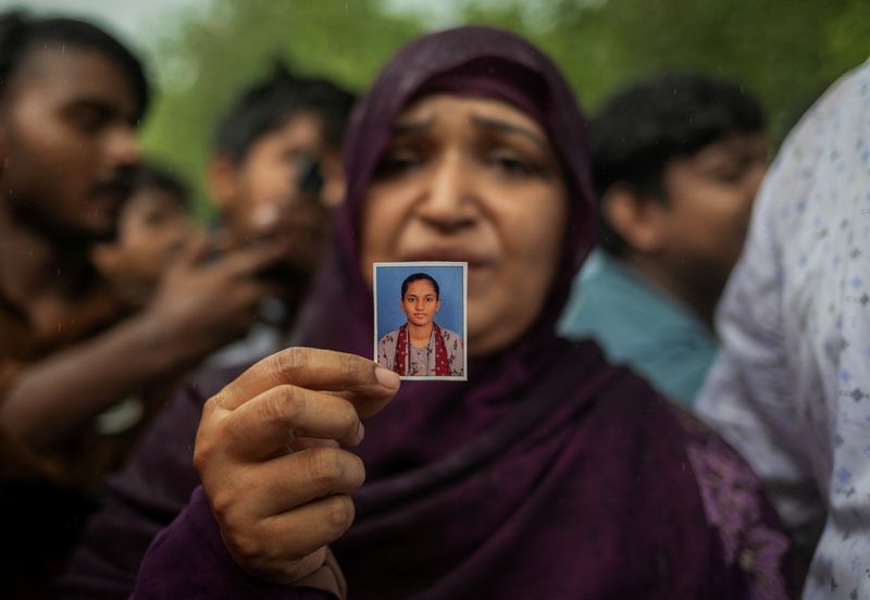 Habibunnisa, mother of Sheikh Sana, 19, an aspirant doctor who took her own life before the National Eligibility cum Entrance Test (NEET) exam retest, shows a picture of her daughter at the Cockroach Janta Party (CJP) protest site, a day after thousands of protesters marched toward parliament demanding the resignation of Education Minister Dharmendra Pradhan over NEET examination paper leaks, at Jantar Mantar in New Delhi, India, July 21, 2026. REUTERS/Adnan Abidi