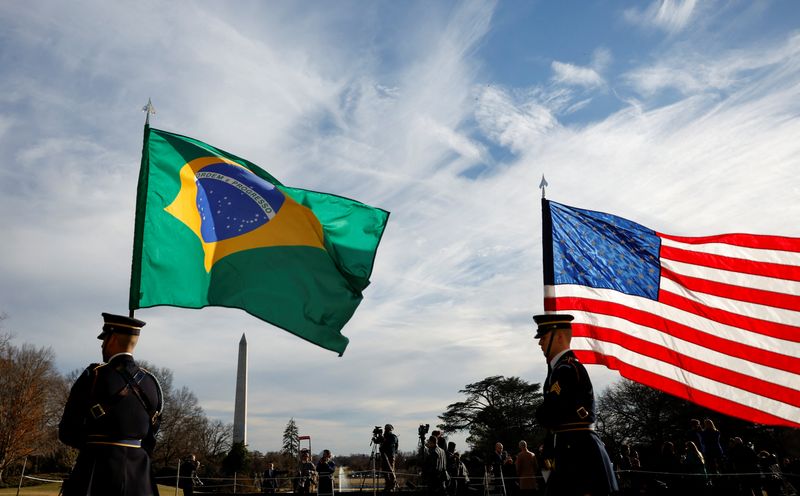 FILE PHOTO: Guards hold U.S. and Brazilian flags at the White House in Washington, U.S., February 10, 2023.  REUTERS/Evelyn Hockstein/ File Photo