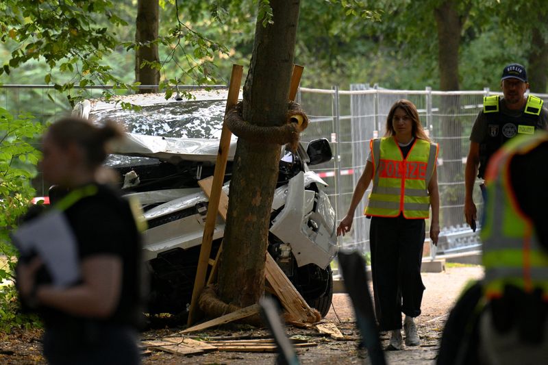 Police walk next to a vehicle which crashed into a crowd near Berlin's annual Christopher Street Day Pride parade on Saturday evening, leaving multiple people injured and the parade called off, in Berlin, Germany, July 26, 2026. REUTERS/Annegret Hilse