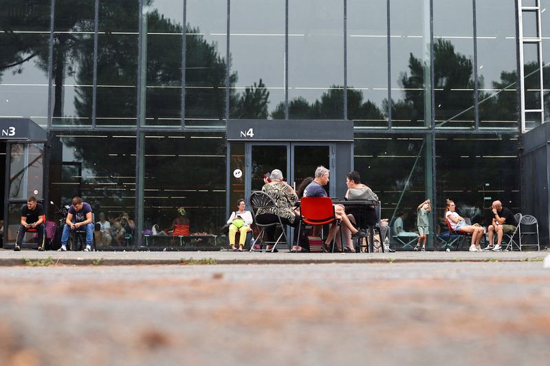 FILE PHOTO: Evacuees wait outside one of the halls at the Bordeaux-Lac Exhibition Centre, which has been turned into a shelter for people displaced by a wildfire burning nearby amid worsening drought conditions following a heatwave and water shortages across much of France, in Bordeaux, France, July 25, 2026. REUTERS/Manon Cruz/File Photo