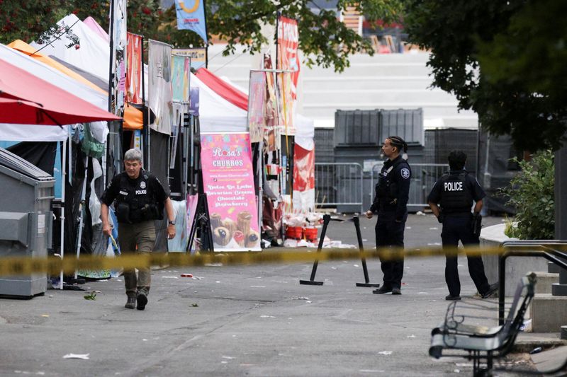 Police officers gather at a site after Seattle Police responded to what they described as a shooting with "multiple" victims at Seattle Center, which was hosting a Bite of Seattle food festival, in Seattle, Washington, U.S., July 26, 2026. REUTERS/Jason Redmond