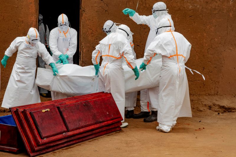 Members of the Civil Protection, a local community-based team that works to help mitigate the spread of the Ebola virus and ensure burials happen safely and quickly, wearing personal protective equipment (PPE), load in to a coffin the body of an unidentified man, who according to his family, died of Ebola, after retrieving it from his house, as aid agencies intensify efforts to contain a new Ebola outbreak involving the Bundibugyo strain, in Bunia, Ituri province, Democratic Republic of Congo, July 10, 2026. REUTERS/Gradel Muyisa Mumbere