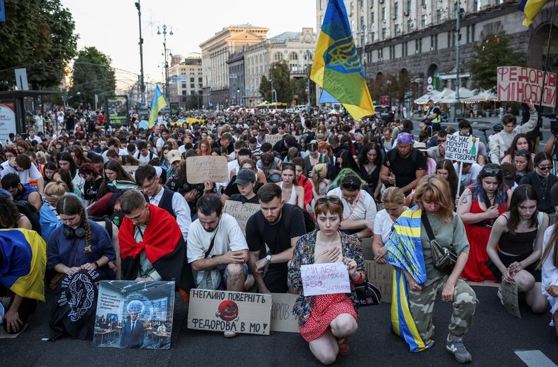 Participants kneel during a moment of silence at a rally to protest against Ukrainian President Volodymyr Zelenskiy's decision to replace Mykhailo Fedorov as Defence Minister, amid Russia's attack on Ukraine, at Khreshchatyk street, in Kyiv, Ukraine, July 31, 2026. REUTERS/Anatolii Stepanov