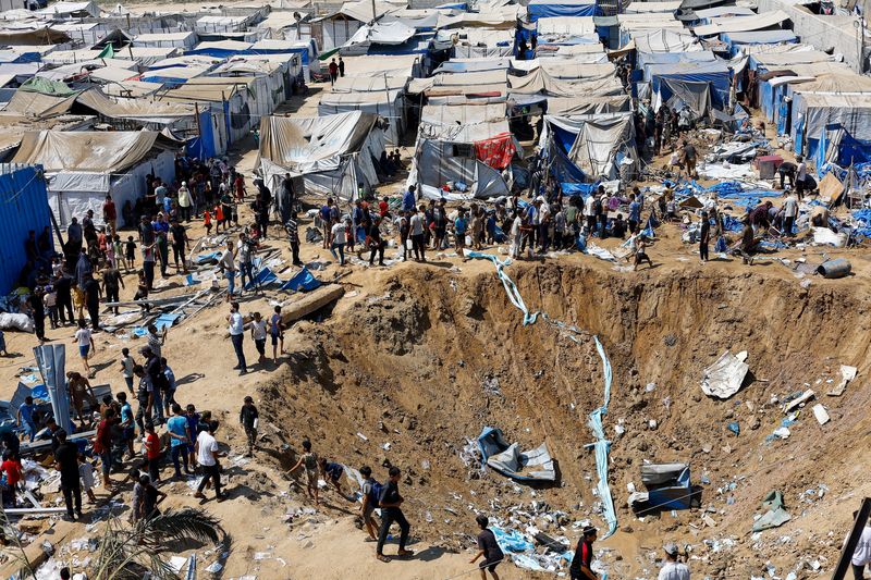 Palestinians inspect the site of an overnight Israeli strike on a medicine warehouse,  according to medics, next to tents sheltering displaced Palestinians, in Deir al-Balah, in the central Gaza Strip, August 1, 2026, residents had been pre-warned by the Israeli military to evacuate. REUTERS/Mahmoud Issa