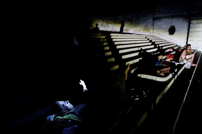 People sleep and rest outdoors on the steps of the University of Havana to escape the heat after Cuba's electricity grid collapsed late on Sunday, plunging the island of about 10 million people into darkness as blackouts become more frequent, in Havana, Cuba August 3, 2026. REUTERS/Norlys Perez