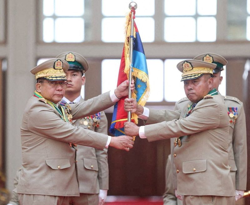FILE PHOTO: Myanmar junta chief Senior General Min Aung Hlaing hands over a flag to newly appointed Commander-in-Chief General Ye Win Oo during a ceremony in Naypyitaw, Myanmar, March 30, 2026. Myanmar Military True News Information Team/Handout via REUTERS