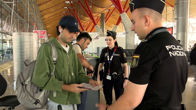 Spanish national police officers check the documents of travellers arriving from Italy, after Spain's government said it would establish border controls for flights and ships from Italy, from midnight on Saturday until September 7, in a dispute over irregular migration, at Madrid-Barajas Airport in Madrid, Spain, August 8, 2026. Spanish Police/Handout via REUTERS