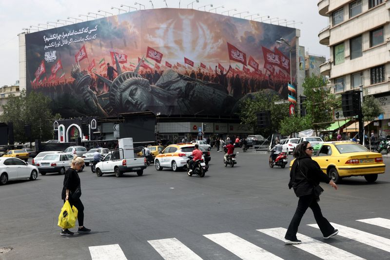 People walk past an anti-U.S. billboard on a street in Tehran, Iran, August 3, 2026. Majid Asgaripour/WANA (West Asia News Agency) via REUTERS