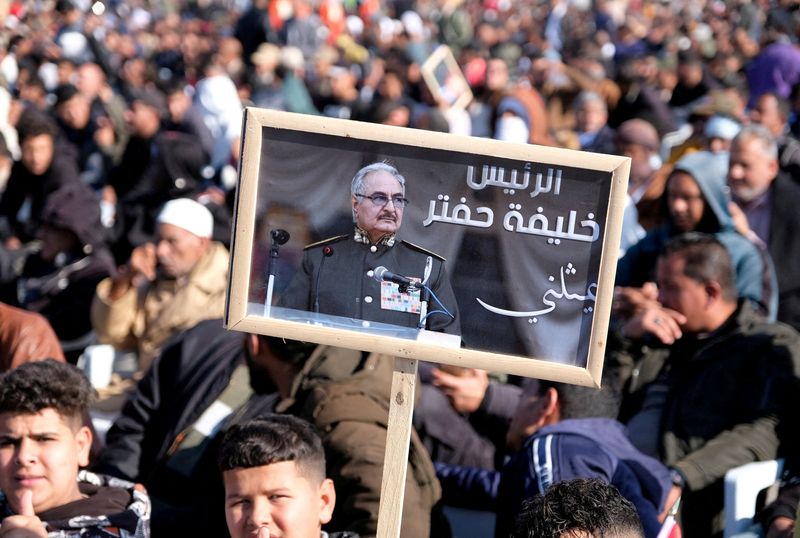 FILE PHOTO: A man holds a picture of commander Khalifa Haftar during Independence Day celebrations in Benghazi, Libya December 24, 2022. REUTERS/Stringer/File Photo