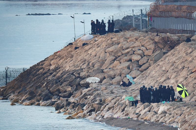 Moroccan security personnel secure the beach on the border with Spain in Ceuta, following mass crossings of migrants on foot and by sea from Morocco into Spanish territory, as seen from Ceuta, Spain, August 15, 2026. REUTERS/Pedro Nunes