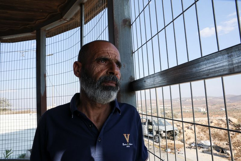Marmar Ouda sits in front of metal bars installed to protect his family from militant settler attacks in the Palestinian village Qusra in the Israeli-occupied West Bank  August 14, 2026. REUTERS/Ammar Awad