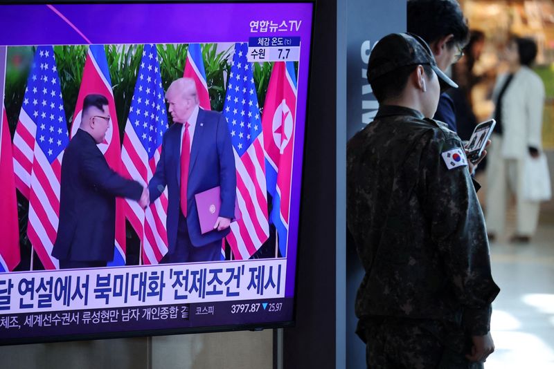 FILE PHOTO: A South Korean soldier stands next to a TV broadcasting a news report on a possible summit between North Korean leader Kim Jong Un and U.S. President Donald Trump, at a railway station in Seoul, South Korea, October 22, 2025.   REUTERS/Kim Hong-Ji/File Photo