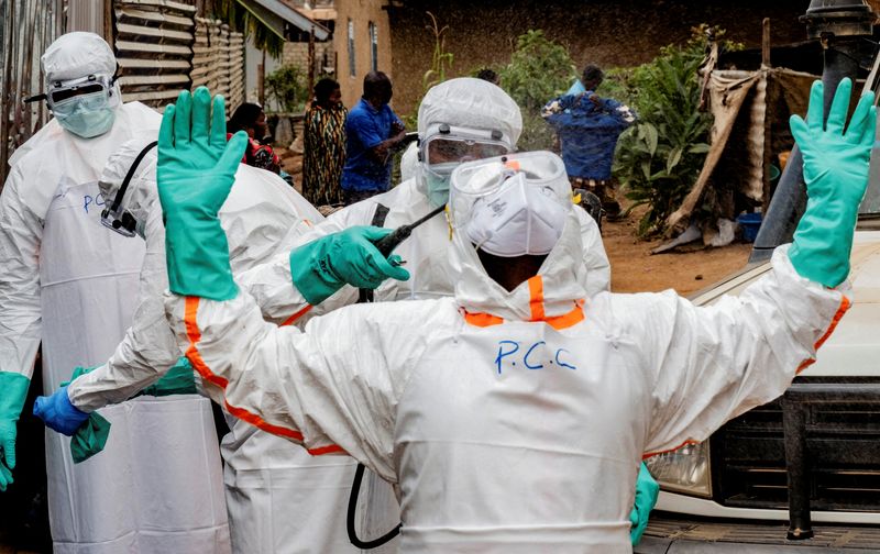 FILE PHOTO: Members of the Civil Protection team, which works to help mitigate the spread of the Ebola virus, wearing personal protective equipment (PPE), disinfect after handling the body of an unidentified man, who according to his family, died of Ebola, in Bunia, Ituri province, Democratic Republic of Congo, July 10, 2026. REUTERS/Gradel Muyisa Mumbere/File Photo