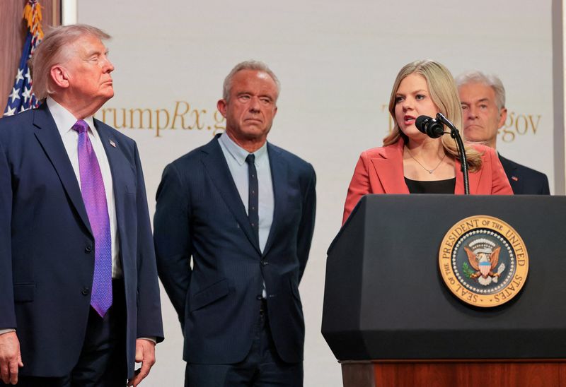 FILE PHOTO: Centre for Medicare & Medicaid Services Administrator Dr Mehmet Oz, U.S. Health and Human Services Secretary Robert F. Kennedy Jr., and U.S. President Donald Trump stand as Heidi Overton speaks during an event to deliver remarks about health care costs and affordability from an auditorium on the White House campus in Washington, D.C., U.S., May 18, 2026. REUTERS/Jonathan Ernst/File Photo