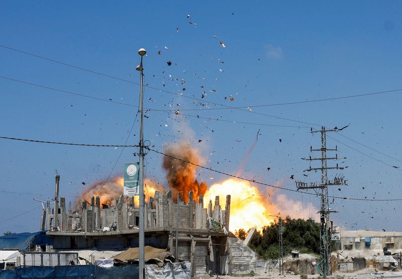 Debris flies through the air, during an Israeli strike, carried out after the Israeli military warned residents to evacuate the area, Al-Zawayda, in the central Gaza Strip,  August 23, 2026. REUTERS/Mahmoud Issa