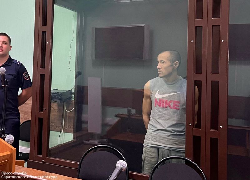 FILE PHOTO: Azamat Iskaliyev, accused of the murder of his ex-girlfriend, stands in a courtroom cage as he is sentenced to 19.5 years in jail, in Saratov, Russia July 9, 2025.  Saratov Regional Court/Handout via REUTERS/File Photo