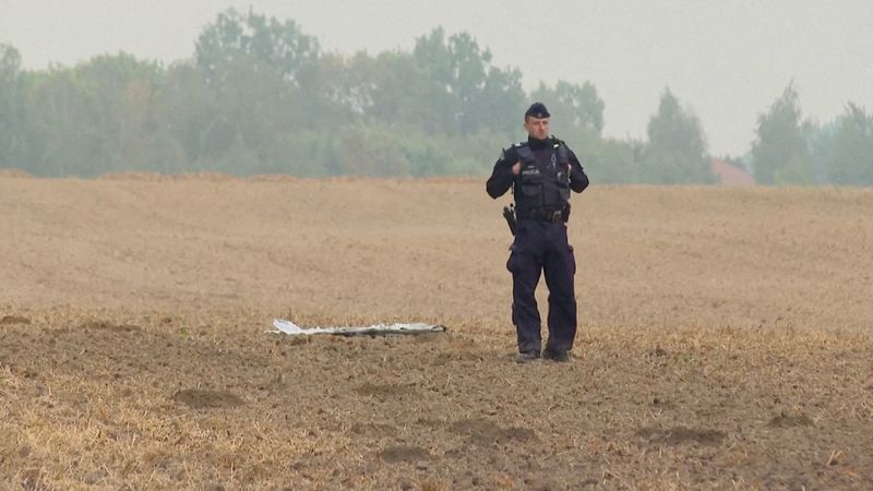 FILE PHOTO: A Polish police officer stands near a unmanned aerial vehicle (UAV) fragment, after Russian drones violated Polish airspace during an attack on Ukraine and some were shot down by Poland, in Czesniki, Lublin Voivodeship, Poland, September 10, 2025 in this still image from video. Polsat News via REUTERS/File Photo
