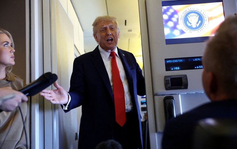 FILE PHOTO: U.S. President Donald Trump speaks to reporters aboard Air Force One on his return from a state visit in Britain, September 18, 2025. REUTERS/Kevin Lamarque/File Photo