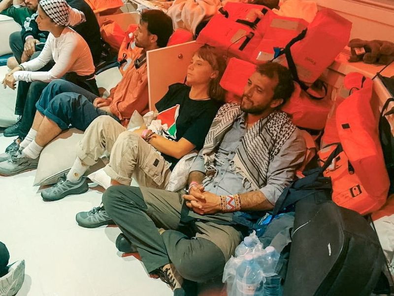 Swedish activist Greta Thunberg and Brazilian activist Thiago Avila sit in a vessel making their way to Israel, after Israel intercepted some of the vessels of the Global Sumud Flotilla aiming to reach Gaza and break Israel's naval blockade, in this handout image released on October 2, 2025. ISRAEL FOREIGN MINISTRY /Handout via REUTERS    VERIFICATION  Reuters was able to verify the identity of the people sitting on the floor as Greta Thunberg and Thiago Avila from their facial features and clothes which matched recent images seen on their social media accounts and Israel Foreign Ministry handout. The exact vessel that they are photographed in could not be confirmed.  The date could also not be verified, however the Israel Foreign Ministry released video of Thunberg and the Global Sumud Flotilla released video of  multiple boats being intercepted on October 1.