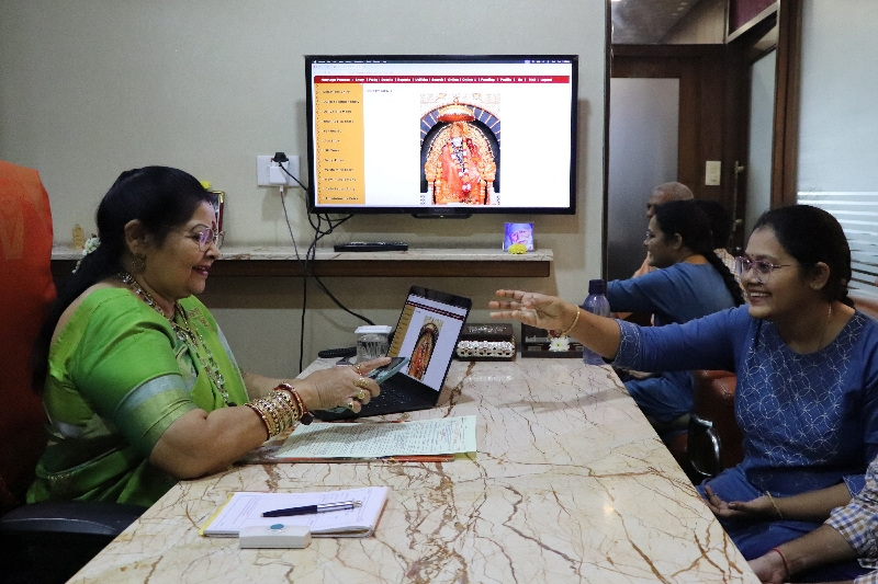Laksmi Chandana, shows a picture of her brother who lives in Australia, to Vanaja Rao, owner of a matchmaking agency, to look for suitable prospect, in Hyderabad, India, October 1, 2025. REUTERS/Almaas Masood