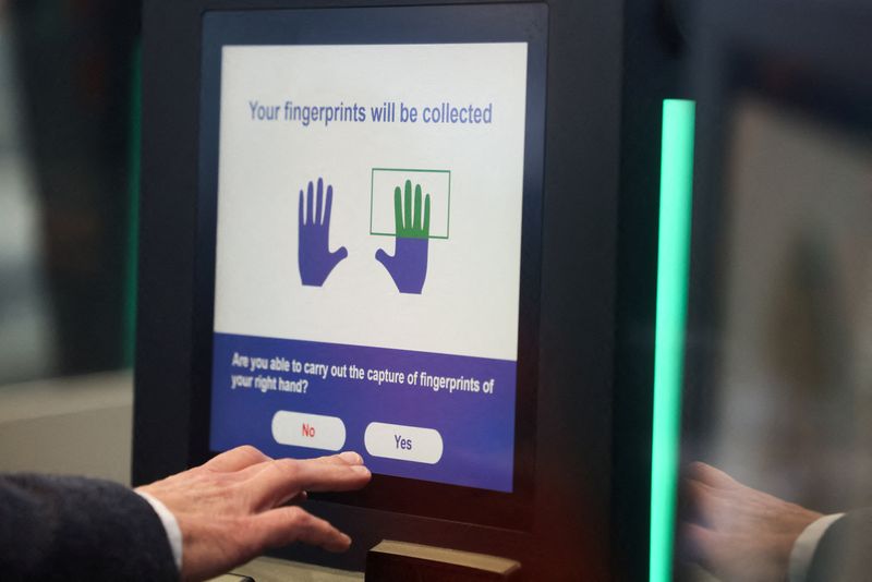 FILE PHOTO: A man operates an automated EES kiosk during a demonstration of the European Union's Entry/Exit System (EES) at the Eurotunnel terminal in Folkestone, Britain, September 23, 2025. REUTERS/Jack Taylor/File Photo