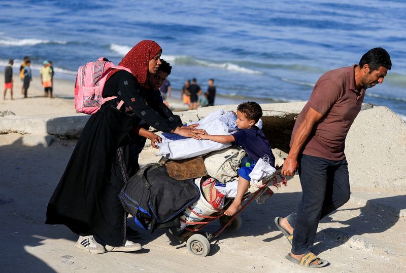 Palestinians, who were displaced to the southern part of Gaza at Israel's order during the war, make their way along a road as they return to the north, amid a ceasefire between Israel and Hamas in Gaza, in the central Gaza Strip, October 11, 2025. REUTERS/Dawoud Abu Alkas