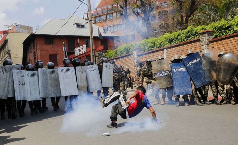 A protester falls down, near a tear-gas canister deployed by riot police, during a nationwide youth-led protest over frequent power outages and water shortages, in Antananarivo, Madagascar, October 11, 2025. REUTERS/Zo Andrianjafy