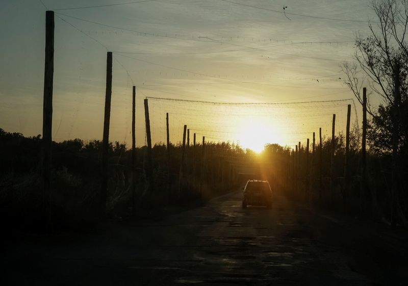 A car drives along a road covered with anti-drone net near the frontline town of Kupiansk, amid Russia's attack on Ukraine, in Kharkiv region, Ukraine October 4, 2025. REUTERS/Sofiia Gatilova