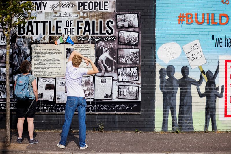 People look at a section of the Peace Wall in Belfast, Northern Ireland, August 2, 2022. REUTERS/Johanna Geron/File Photo