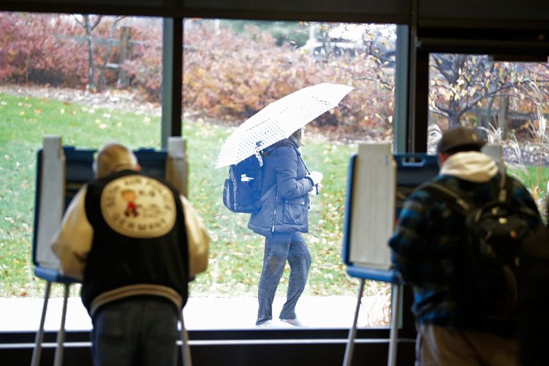 A student walks past as voters cast their ballots at the UW-Green Bay campus on Tuesday, November 6, 2018, in Green Bay, Wis.