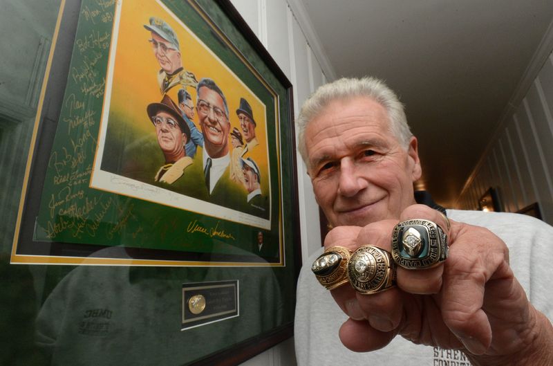Former Green Bay Packers player Tom Brown displays his Super Bowl and NFL Championship rings at his home in 2014. The rings will be auctioned later this month.