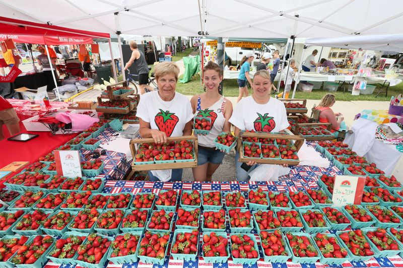 Berry sellers including Cheryl Schmit (from left), Clair Paul and Donna Bornitz get a workout at the popular Cedarburg Strawberry Festival.