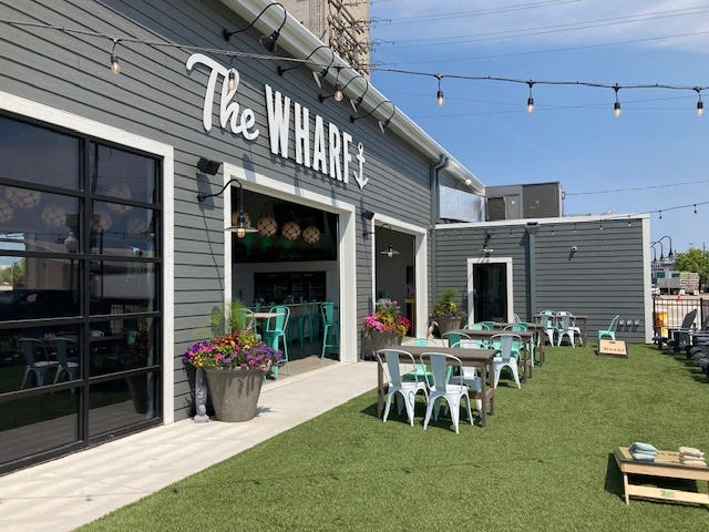 An outdoor area features seats in the grass and outdoor games to play while sipping on drinks or waiting on food orders.