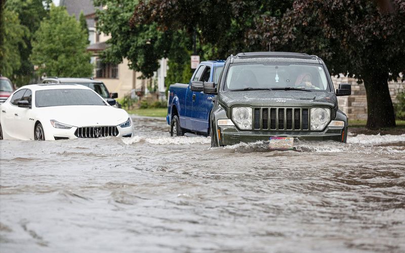 Drivers make their way around a stalled car Thursday, July 9, 2020, on Park Avenue near First Street in Fond du Lac, Wis. A large amount of rain in a short period of time caused streets to flood throughout the city of Fond du Lac.
