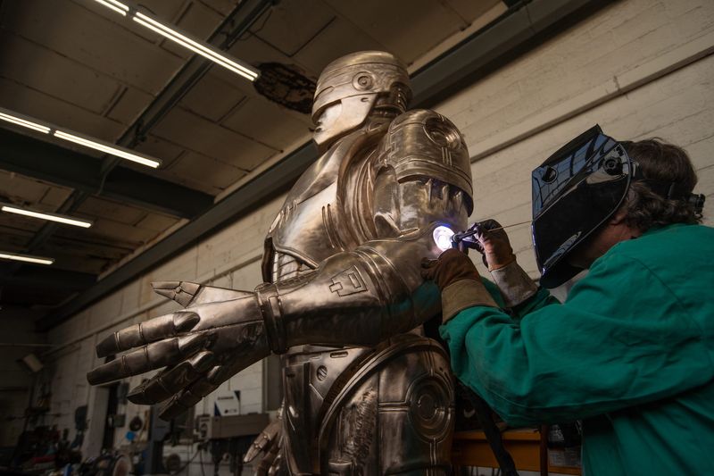 Jay Jurma welds a small section of an 11-foot RoboCop statue at a warehouse on Detroit's east side on Feb. 24, 2021, while finishing the statue before its patina is applied.