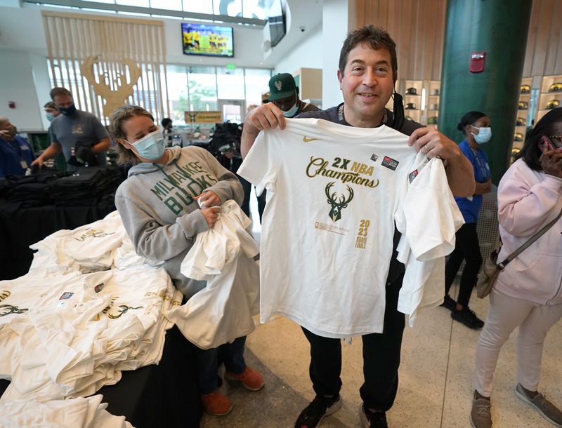 Milwaukee Bucks President Peter Feigin, with his wife Natalia, left, shop for Bucks Championship merchandise at the Bucks Pro Shop at Fiserv Forum in Milwaukee July 21, 2021.