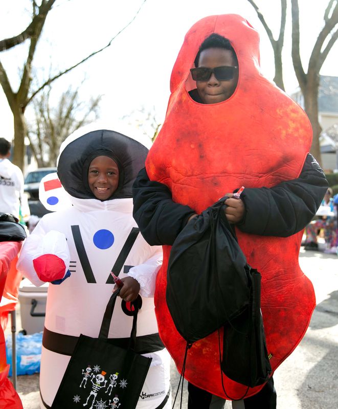 Ian Thompson, 7, dressed up as an astronaut, and Jansen Jones, 12, dressed up as a Hot Cheeto, pose together for a photo during the Active Street Safe Trick-or-Treat & Harvest Fest in Milwaukee on Oct. 28, 2023.