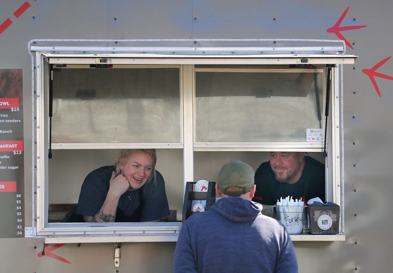 Co-owners Essa and Aaron Cole talk with a customer at Hot Biddy’s food truck serving Nashville Style Fried Chicken on Wednesday, April 10, 2024 in Appleton, Wis. 
Wm. Glasheen USA TODAY NETWORK-Wisconsin