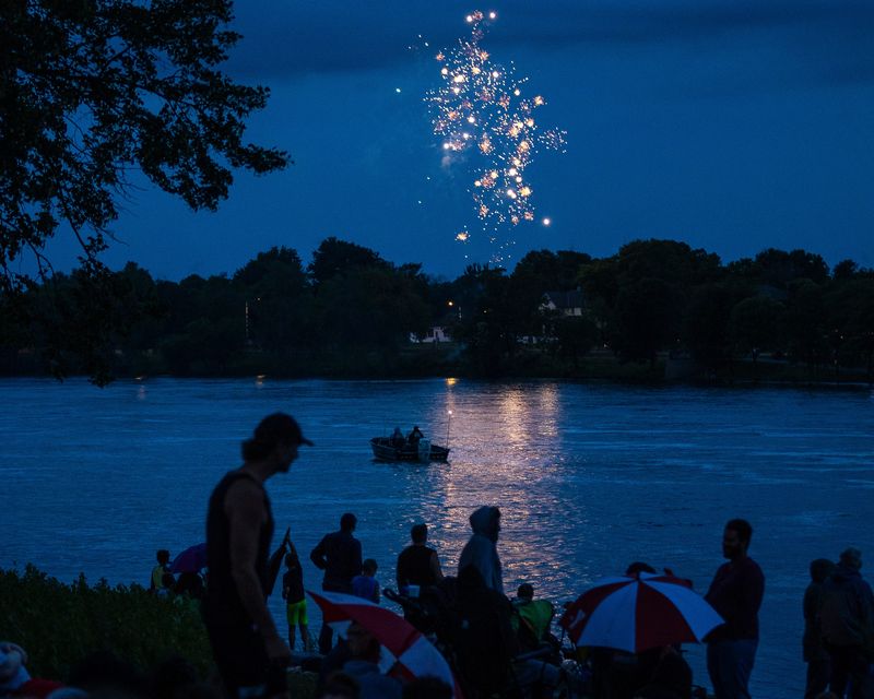 Wisconsin Rapids holds their annual Independence Day fireworks through the heavy rain over the Wisconsin River in Wisconsin Rapids, Wis. on Thursday, July 4, 2024. Spectators gathered closely under tarps, trees and umbrellas to avoid what rain they could while still finding which ever spaces they could in Veterans Memorial Park or on the West Grand Avenue Bridge to catch sight of the explosive show.