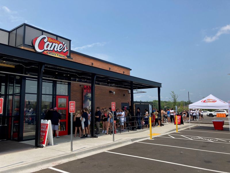 Long lines of vehicles and people appeared early in the day for the grand opening of Raising Cane's in Greendale on Tuesday, July 30, 2024 It is the first Raising Cane's to open in the Milwaukee County area.