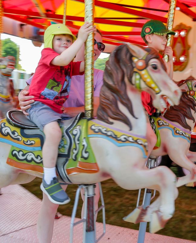 Eliott Nagode, 3, of Sheboygan, smiles as he rides the Merry-go-Round during the Sheboygan Jaycees Brat Day at Kiwanis Park, Saturday, August 3, 2024, in Sheboygan, Wis.