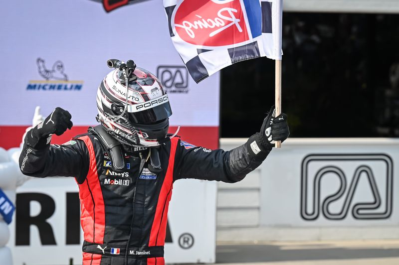 Mathieu Jaminet celebrates with the checkered flag after winning after winning in the Penske Porsche 963 he shared of Nick Tandy in the 2024 IMSA WeatherTech race at Road America.
