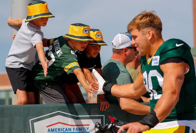 Young fans reach out to slap hands with Green Bay Packers defensive lineman Lukas Van Ness (90) in the DreamDrive before the 12th practice of training camp on Tuesday, August 6, 2024, at Lambeau Field in Green Bay, Wis. 
Tork Mason/USA TODAY NETWORK-Wisconsin