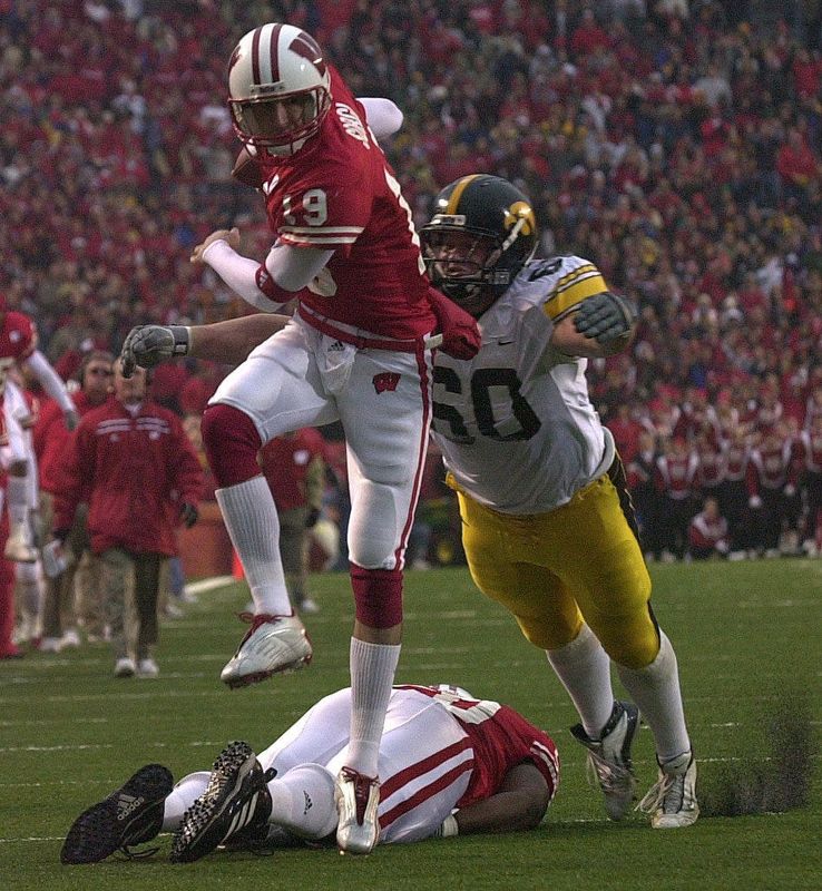Wisconsin Quarterback Jim Sorgi jumps over teammate Jonathan Clinkscale as Iowa's Tyler Luebke tries to take him down during the first quarter on November 22, 2003, at Camp Randall Stadium in Madison. Iowa won 27-21.