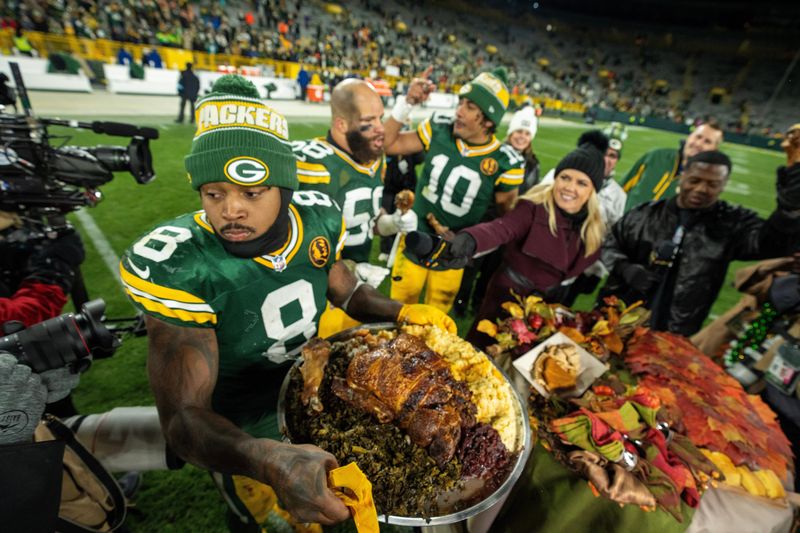 Green Bay Packers running back Josh Jacobs (8) carries a turkey back to the locker room after their game Thursday, Nov. 28, 2024 at Lambeau Field in Green Bay, Wisconsin. The Packers beat the Miami Dolphins, 30-17.
